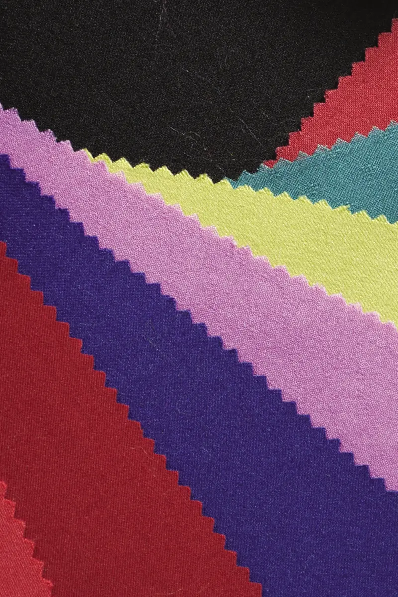 Fabric swatches with zigzag edges fanned out in red, purple, pink, lime, teal and black.