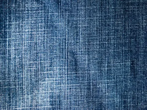 Close-up of indigo blue denim fabric showing its diagonal twill weave.