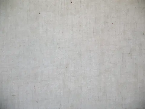 Close-up of heavy off-white cotton canvas showing its coarse plain weave.